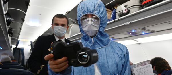 Медициналык кызматкер учактагы жүргүнчүлөрдү текшерип жатат тепловизор менен. Архив - Sputnik Кыргызстан