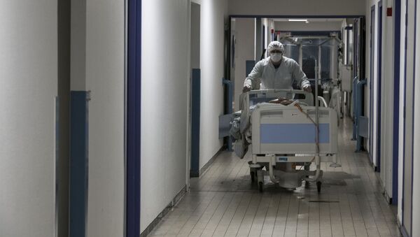 Медсотрудник ведет пациента с COVID-19 в отделение неотложной помощи - Sputnik Кыргызстан