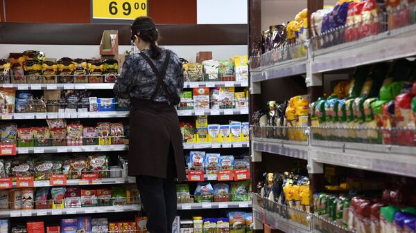 Сотрудница торгового зала выкладывает продукцию на полку в супермаркете. Архивное фото - Sputnik Кыргызстан