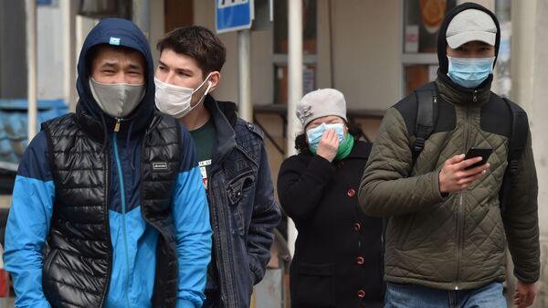 Люди в медицинских масках идут по одной из улиц Бишкека. Архивное фото - Sputnik Кыргызстан