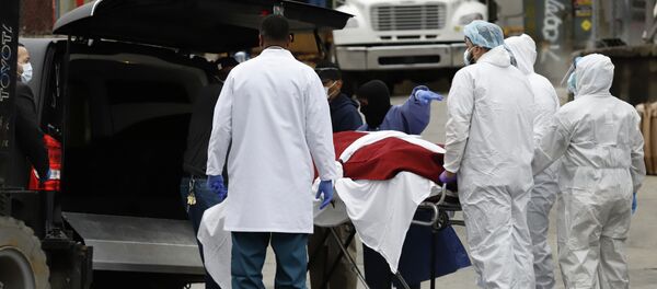 Медициналык кызматкерлер коронавирус менен оруган кишини катафалк-унаага салып жатышат. Архив - Sputnik Кыргызстан