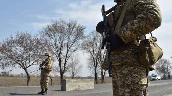Военнослужащие в медицинской маске стоит на контрольно-пропускном пункте - Sputnik Кыргызстан