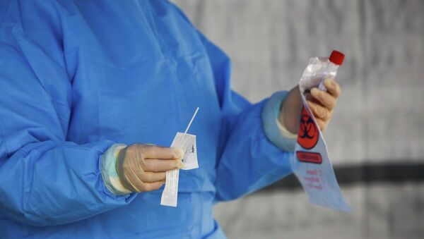 Медицинский работник держит пробирку с тест-системой на коронавирус - Sputnik Кыргызстан