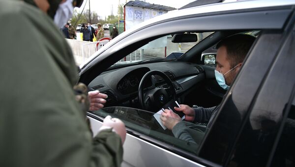 Сотрудник МВД проверяет документы на контрольно-санитарном пункте в городе Бишкек - Sputnik Кыргызстан