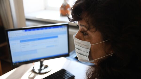 Женщина в медицинской маске за копьютером. Архивное фото - Sputnik Кыргызстан
