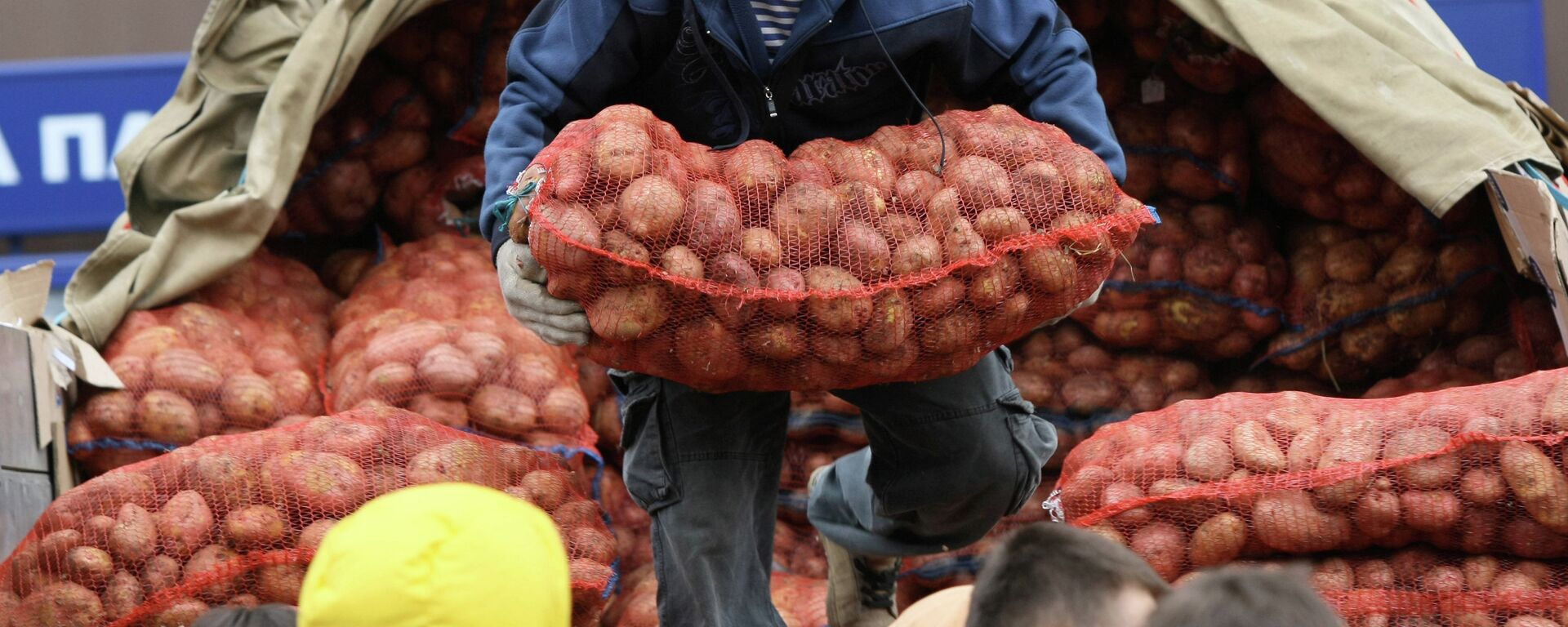 Мужчина выгружает мешок картофеля из кузова грузовика. Архивное фото  - Sputnik Кыргызстан, 1920, 10.12.2023