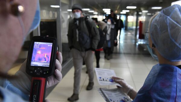 Медицинские сотрудники измеряют температуру прибывших пассажиров с помощью тепловизора. Архивное фото - Sputnik Кыргызстан
