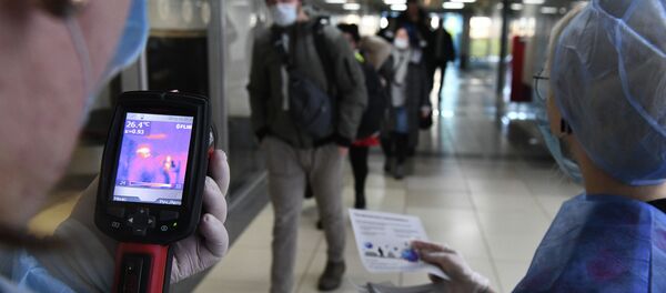 Медицинские сотрудники измеряют температуру прибывших пассажиров с помощью тепловизора. Архивное фото Медицинские сотрудники измеряют температуру прибывших пассажиров с помощью тепловизора. Архивное фото - Sputnik Кыргызстан