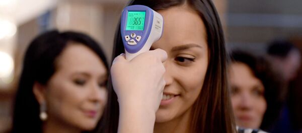 Девушке замирают температуру тепловизором. Архивное фото Девушке замирают температуру тепловизором. Архивное фото - Sputnik Кыргызстан