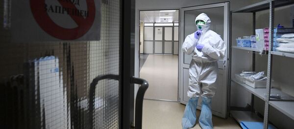 Сотрудник больницы одевает защитный костюм. Архивное фото - Sputnik Кыргызстан