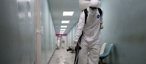 Сотрудник дезинфекционной бригады гражданской защиты проводит обработку поверхностей дезинфицирующим раствором в общей больнице  - Sputnik Кыргызстан