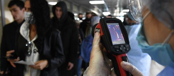 Медициналык кызматкерлер тепловизор менен жүргунчүлөрдү текшерип жатышат. Архив - Sputnik Кыргызстан