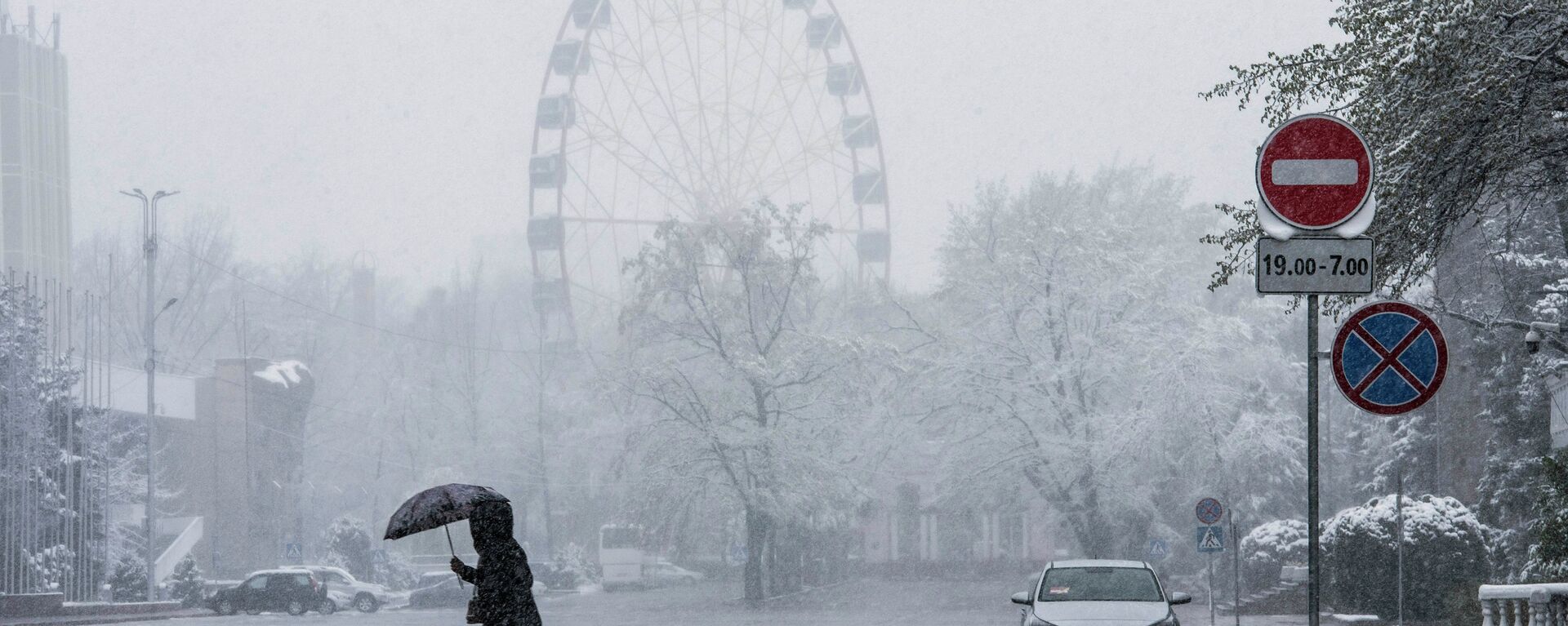 Девушка с зонтом переходит дорогу на Старой площади во время снегопада в Бишкеке. Архивное фото  - Sputnik Кыргызстан, 1920, 11.01.2024
