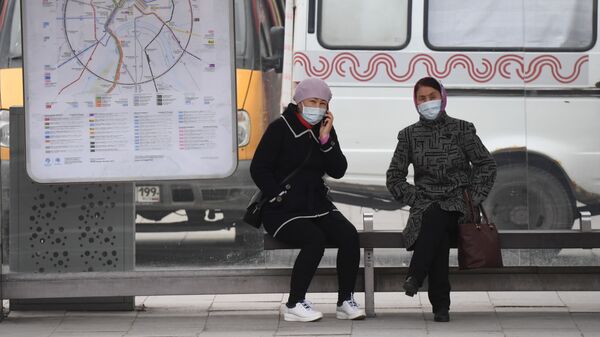 Женщины в медицинских масках на остановке в Москве. Архивное фото - Sputnik Кыргызстан