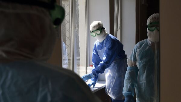 Медики, одетые в защитные комбинезоны, очки, маски перчатки, в городской больнице - Sputnik Кыргызстан