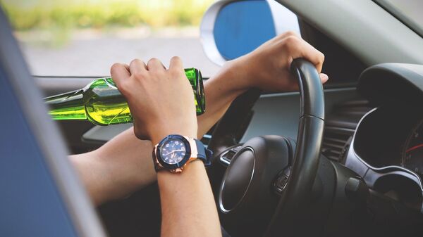 Водитель пьет спиртной напиток за рулем. Иллюстративное фото - Sputnik Кыргызстан