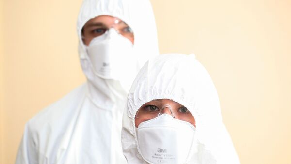 Врачи в защитных масках и костюмах во время работы в больнице. Архивное фото - Sputnik Кыргызстан