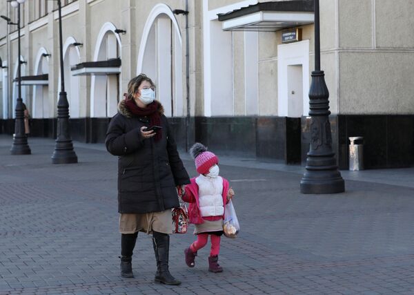 Женщина с ребенком в защитных масках на железнодорожном вокзале в Киеве, Украина - Sputnik Кыргызстан