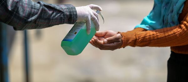 Медицина кызматкери кишинин колун дезинфекция кылуу учурунда. Архив - Sputnik Кыргызстан