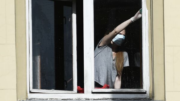 Девушка в защитной маске моет окно у своей квартире. Архивное фото - Sputnik Кыргызстан