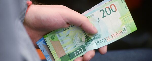 Мужчина держит в руке российские рубли. Архивное фото - Sputnik Кыргызстан