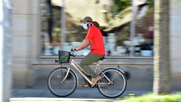 Человек одетый в защитную маску едет на велосипеде. Архивное фото - Sputnik Кыргызстан