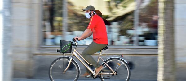 Человек одетый в защитную маску едет на велосипеде. Архивное фото - Sputnik Кыргызстан