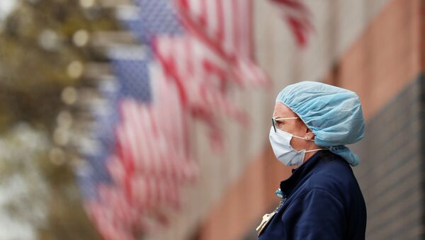 Медсестра в защитной маске около больницы Элмхерст в районе Квинс, Нью-Йорк, США - Sputnik Кыргызстан