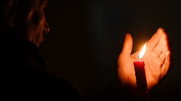 Человек с зажженной свечей в руках. Архивное фото - Sputnik Кыргызстан