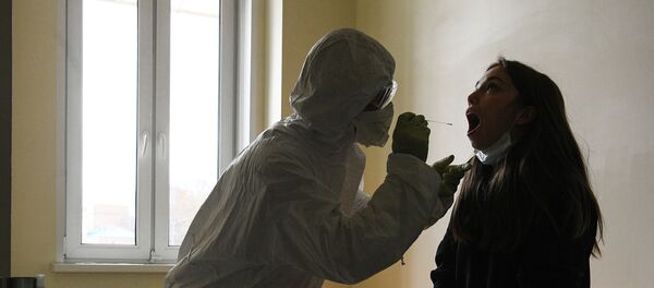 Медицинский работник берет у пациентки анализ на коронавирус. Архивное фото - Sputnik Кыргызстан