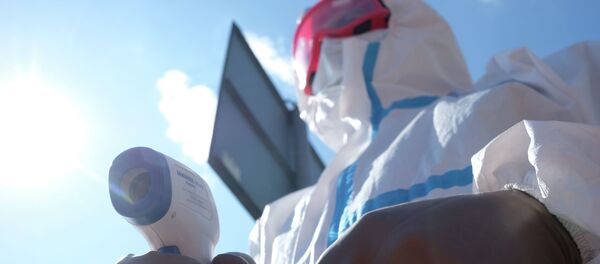 Медициналык кызматкер термометр менен турган учурда. Архив - Sputnik Кыргызстан