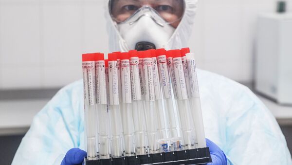 Сотрудник лаборатории держит в руках пробирки с биоматериалом для тестирования на коронавирусную инфекцию. - Sputnik Кыргызстан
