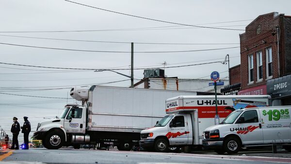 Сотрудники полиции Нью-Йорка охраняют грузовики с телами людей найденные в Бруклинском районе Нью-Йорка - Sputnik Кыргызстан