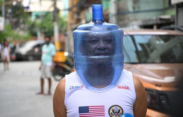 Мужчина в импровизированном защитном шлеме от коронавируса, сделанном из пластиковой бутыли, Манила - Sputnik Кыргызстан