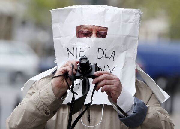 Фотограф в защитной маске, сделанной из бумажного пакета, в Варшаве, Польша - Sputnik Кыргызстан