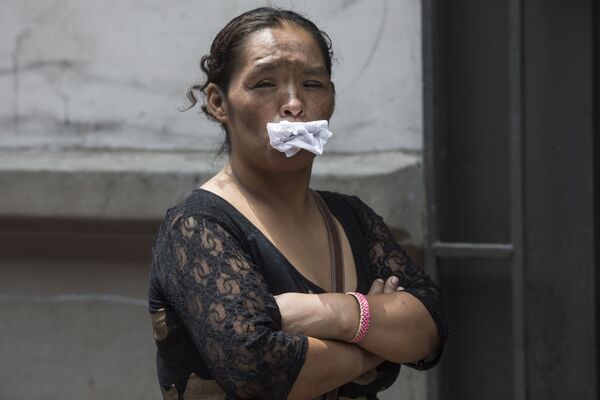Женщина держит бумагу во рту, как альтернативу маске, в очереди бесплатный обед для бездомных в Лиме, ​​Перу - Sputnik Кыргызстан