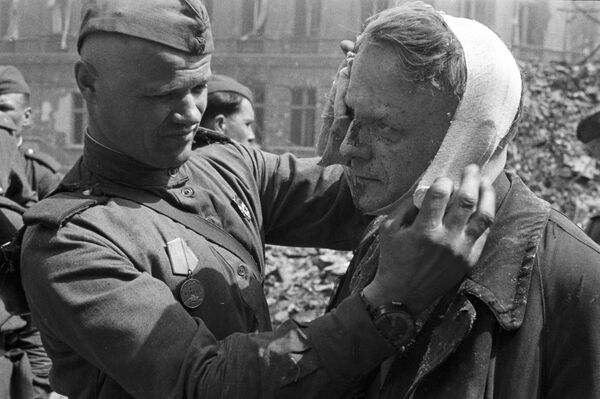 Советский солдат делает перевязку раненому берлинцу, 1945 год - Sputnik Кыргызстан