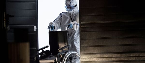 Медик карантинного центра с коляской для пациентов. Архивное фото - Sputnik Кыргызстан
