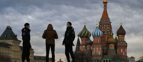 Сотрудники полиции и прохожий на Красной площади в Москве в дни действия режима повышенной готовности из-за коронавируса - Sputnik Кыргызстан