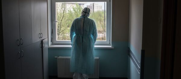 Медицинский работник стоит у окна в больнице Медицинский работник стоит у окна в больнице - Sputnik Кыргызстан
