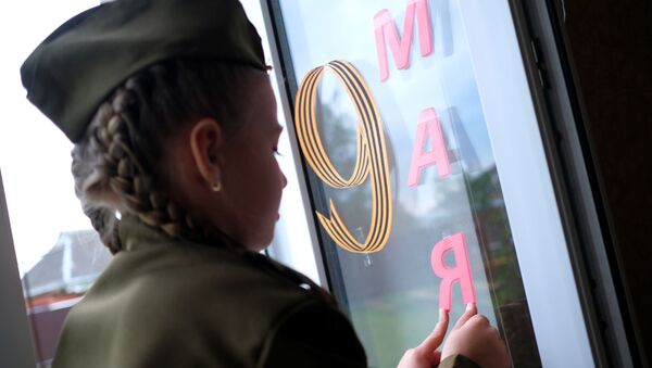 Юная участница всероссийской акции Окна Победы украшает к празднику 9 мая окно своей квартиры. Архивное фото - Sputnik Кыргызстан