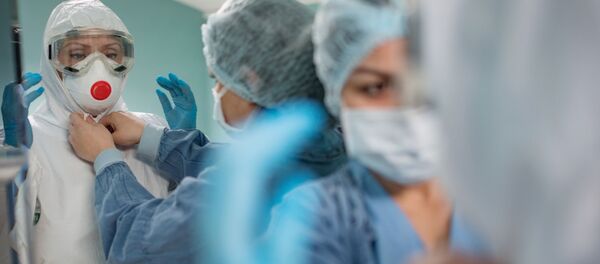 Врачи одевают защитный костюм и маску в стационаре для больных с коронавирусной инфекцией в госпитале в Москве. - Sputnik Кыргызстан