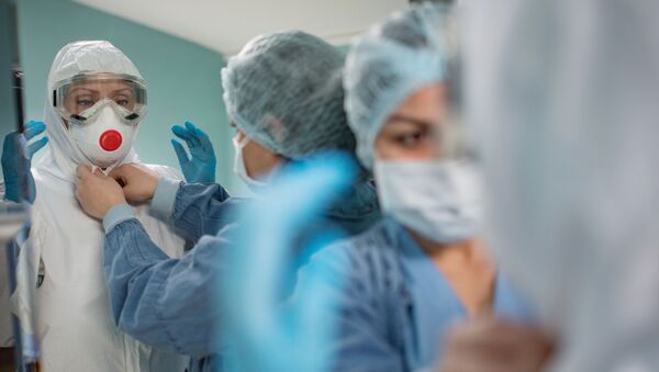 Врачи одевают защитный костюм и маску в стационаре для больных с коронавирусной инфекцией в госпитале в Москве. - Sputnik Кыргызстан