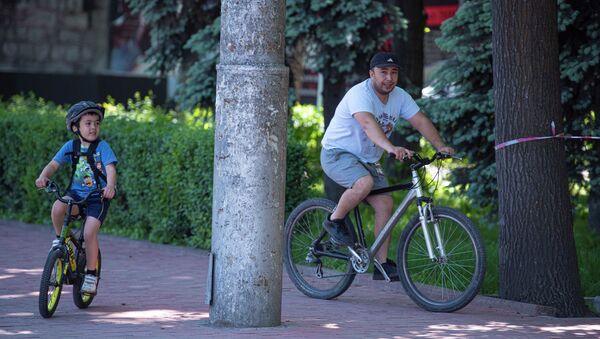 Бишкекте өзгөчө кырдаал аяктагандан кийин эркек киши менен бала велосипед тээп жатышат - Sputnik Кыргызстан