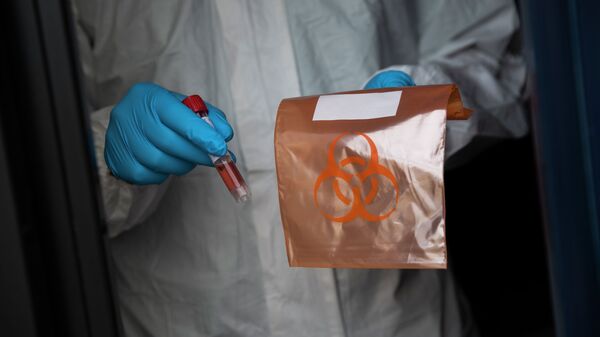 Медицинский сотрудник держит образец взятый у пациента для тестирования COVID-19. Архивное фото - Sputnik Кыргызстан
