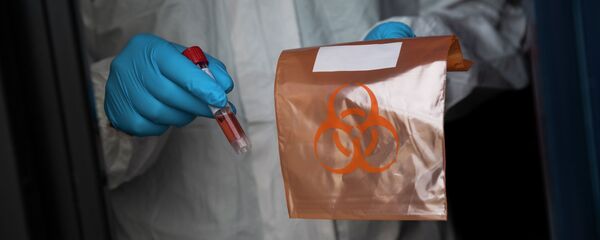Медицинский сотрудник держит образец взятый у пациента для тестирования COVID-19 - Sputnik Кыргызстан