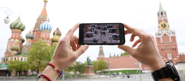 Киши Москвадагы Кызыл аянтта Өлбөс полктун трансляциясын көрүп жатат. Архив - Sputnik Кыргызстан