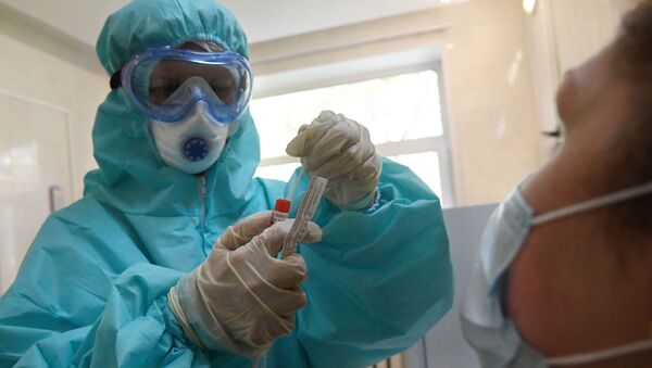 Медицинский работник в защитном костюме проводит забор биоматериала для анализа на коронавирус. Архивное фото - Sputnik Кыргызстан