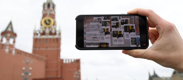 Молодой человек смотрит трансляцию акции Бессмертный полк на Васильевском спуске в Москве. - Sputnik Кыргызстан