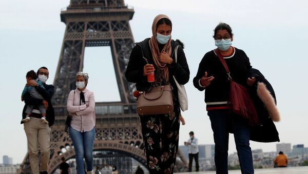 Люди в медицинских масках идут по площади Трокадеро возле Эйфелевой башни, Париж. Архивное фото - Sputnik Кыргызстан